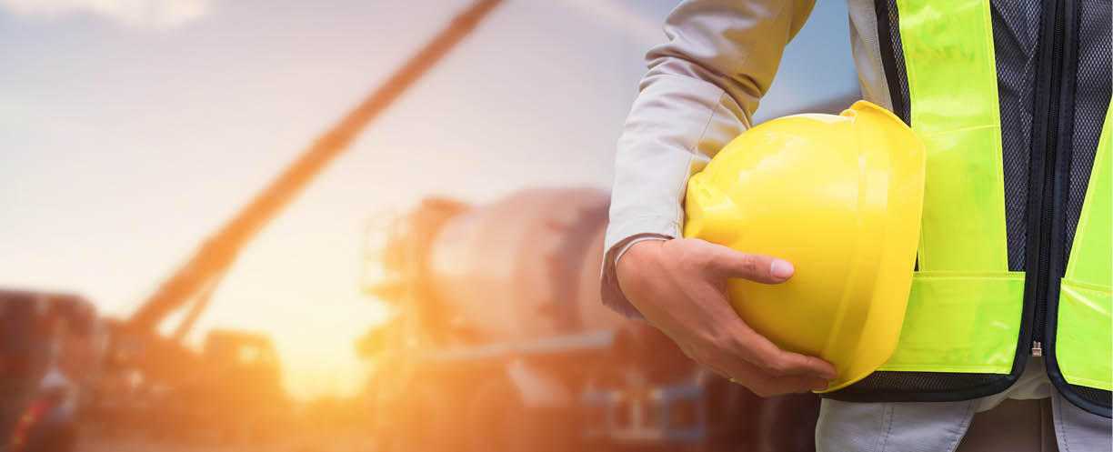 Engineer or Safety officer holding hard hat with the mobile crane machine is background in construction site.