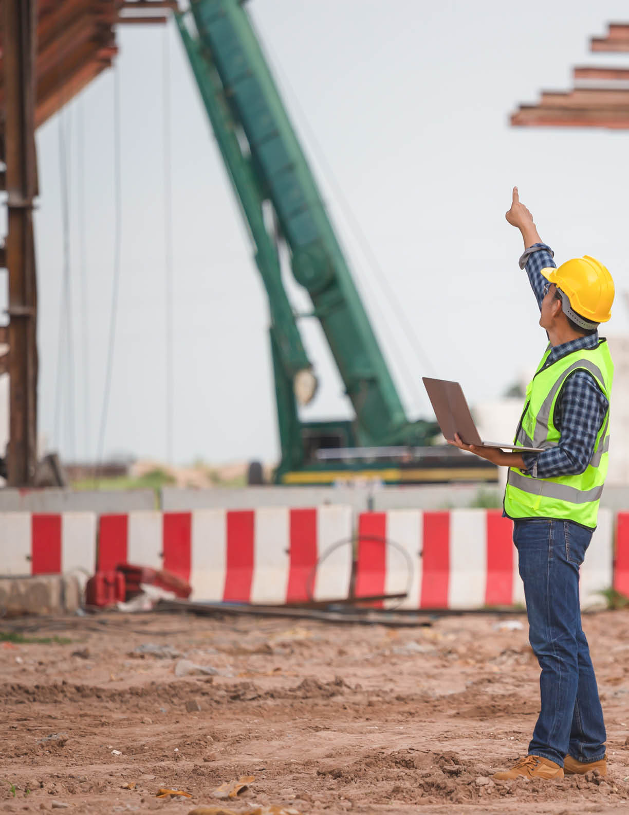 Engineer man with laptop checking project at infrastructure construction site, Foreman worker in building site