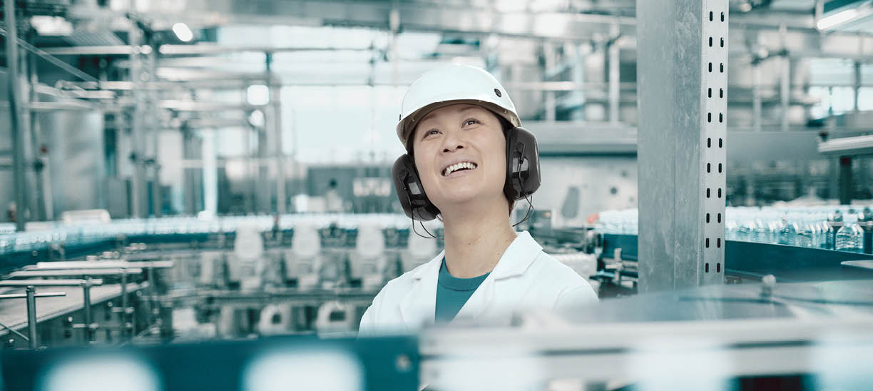 Young Handsome Smiling Scientist With Clipboard Posing in Factory
